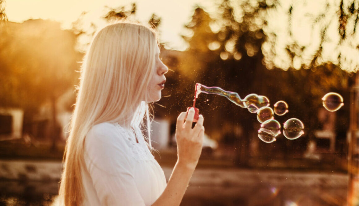 woman-blowing-bubbles-during-sunset-alkJl-mokOY