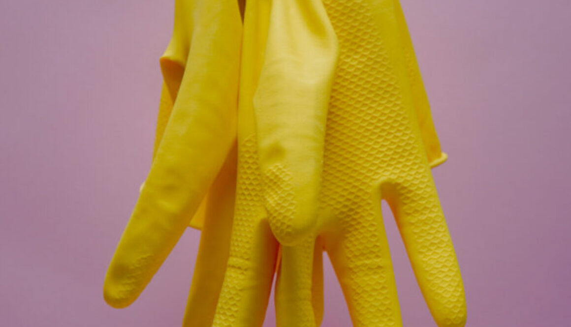 Yellow cleaning gloves hanging from a string.karolina-kolodziejczak