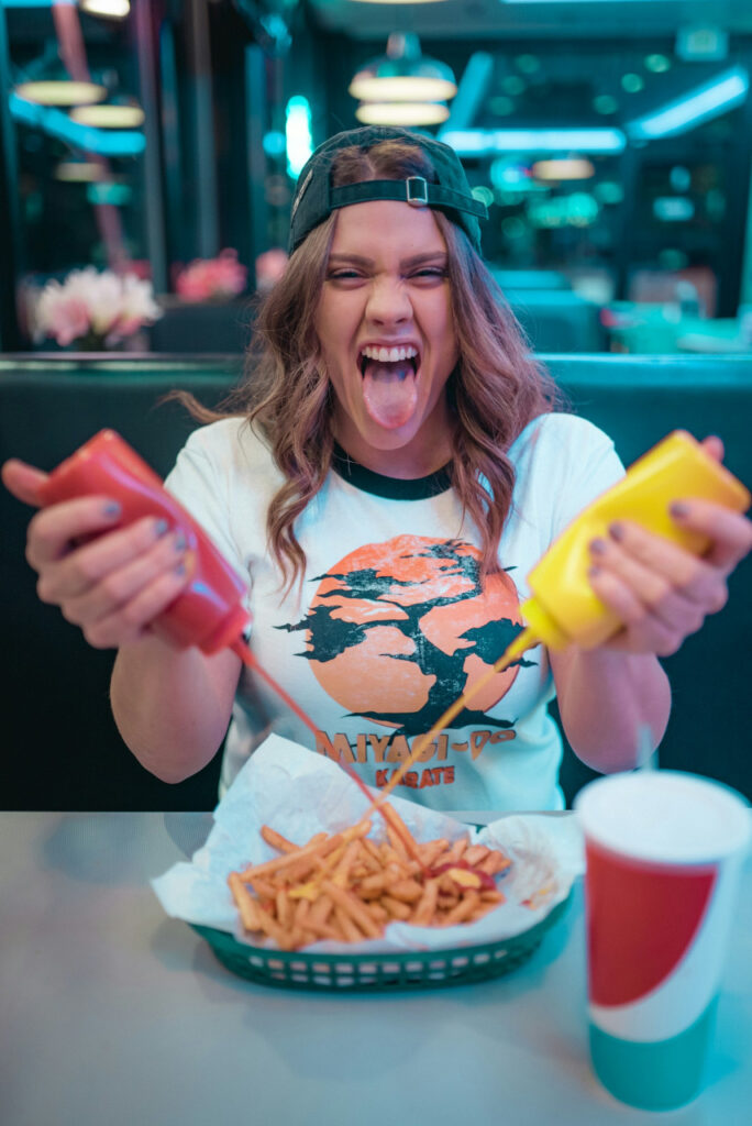 woman-in-white-and-red-mickey-mouse-crew-neck-t-shirt-holding-french-fries-s2MjR3xoJkE