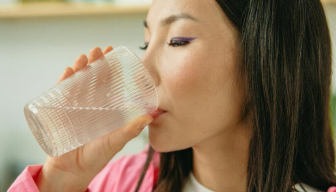 woman-in-pink-long-sleeve-shirt-drinking-water-8845636/