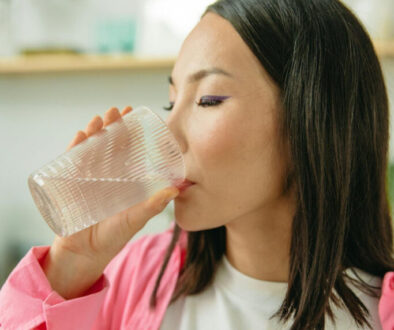 woman-in-pink-long-sleeve-shirt-drinking-water-8845636/