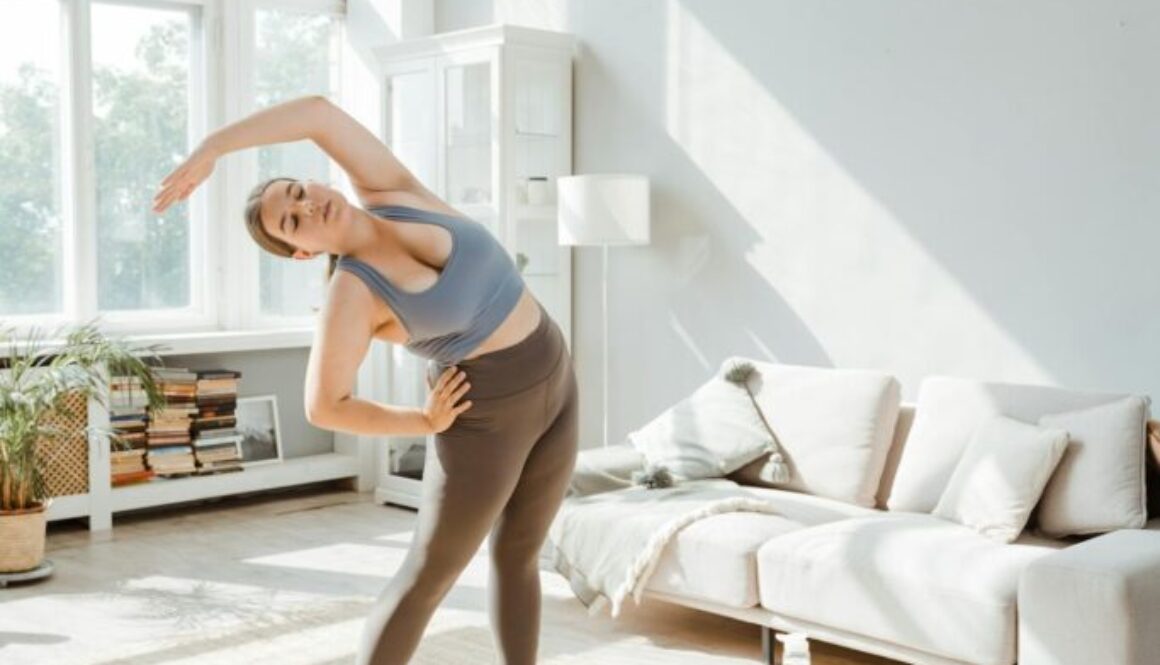 a-woman-in-activewear-stretching-her-arms-at-home-8846094/