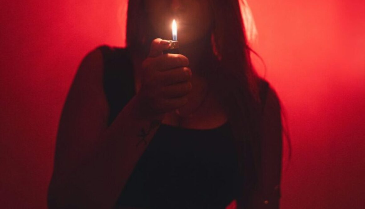 mysterious-woman-holding-lighter-in-dark-room-30197148/